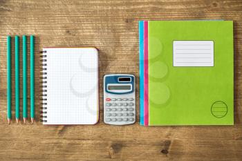   Digital calculator,open notebook,exercise books and pencils.Top view.