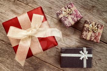 Four festive gift boxes on old wooden floor