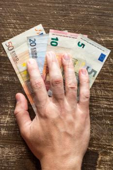 Hand is taking Euros. Concept for bribery or fraud.