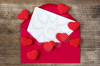  Open envelope with love letter and red hearts on the wooden background