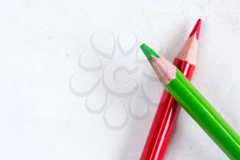Red and green pencils with copy-space on old paper 