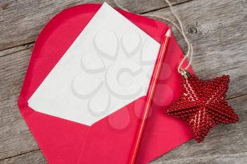 Blank letter with red pencil and Christmas star on wooden background