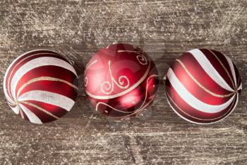 Christmas background with three red  balls on wooden board