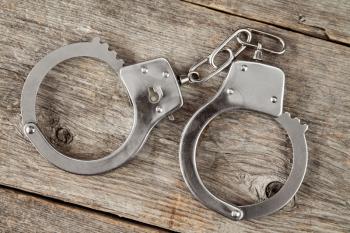 Top view of handcuffs on the wooden background