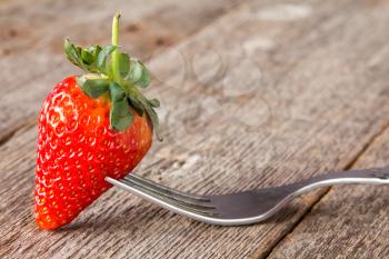 Fork with fresh strawberry, ready to eat