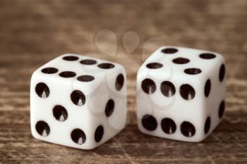 Two dice on dark wooden table background. Gambling concept.