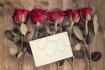Five red roses and blank card for copy-space