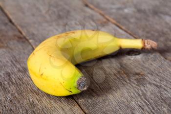 Close-up of yellow banana lying on wooden background