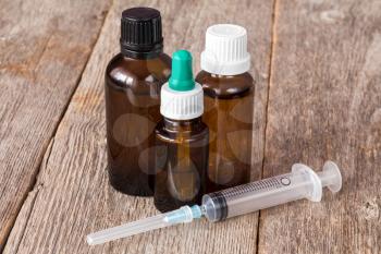 Medical syringe and bottles kits  on wooden background