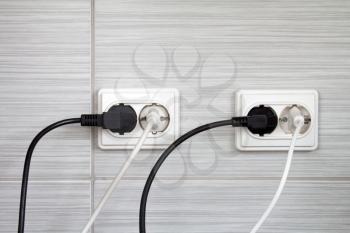 Electrical plugs connected into the wall sockets