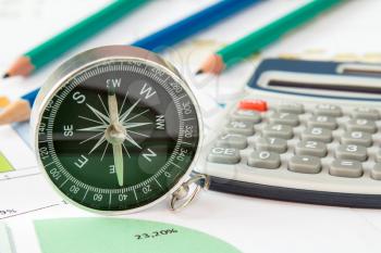 Business graphs and finances with a compass and calculator