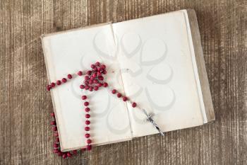 Catholic rosary on opened book with blank pages.Copy-space.