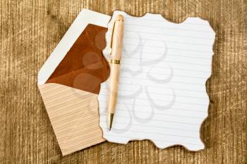Open envelope with burned letter on the wooden background