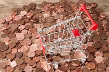 Pile of Euro cent coins and empty shopping cart