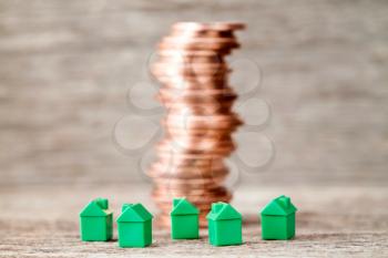 Miniature houses and copper coins stack. Concept for mortgage,property ladder and real estate investment
