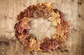 Autumn leaves circle with copy space on wooden background