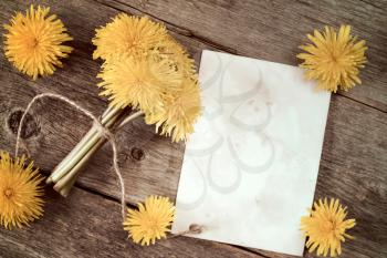 Dandelion flowers and blank card on wooden table top view