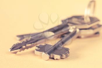  Bunch of keys lying on yellow background. Filtered image.