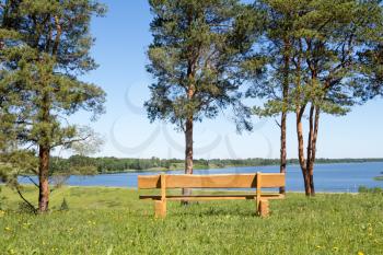 Empty wooden bench at park with lake view,ideal place for resting
