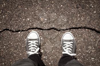 Man standing on cracked damaged city asphalt floor