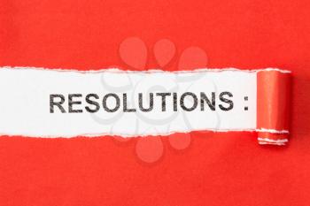 The phrase RESOLUTIONS appearing behind torn paper