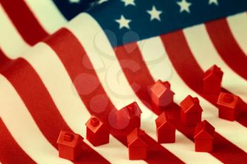 Mini houses against USA flag background. Citizenship, residence, property, real estate concept.