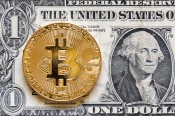 Golden bitcoin coin on US dollar background, close up view
