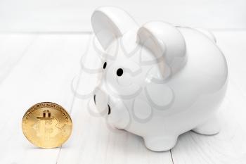 Piggy bank and Bitcoin. Concept of saving and investing in virtual currency