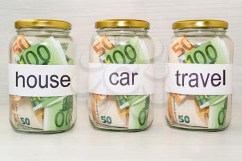 Saving money into glass jar for future investment