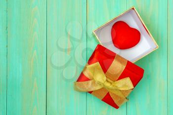 Red heart in gift box on wooden plank. Concept for valentine day.