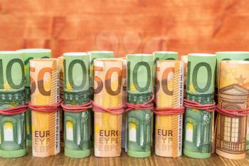 Euro banknote rolls in one row. Copy-space. 