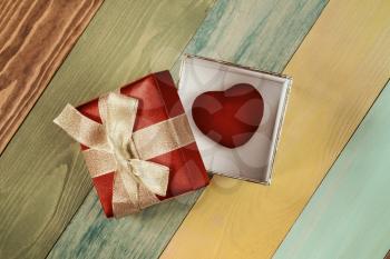 Valentine's day background, gift box with  heart inside on color wooden background
