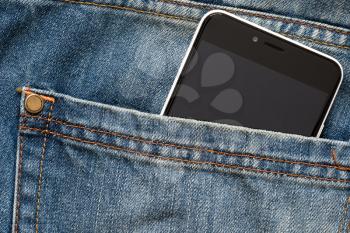 Mobile phone with black screen in jeans pocket 