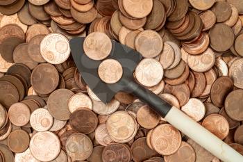 Shovel with coins. Profit or investment concept