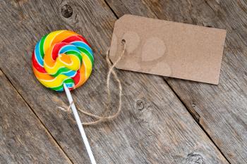 Lollipop with a tag on a wooden background