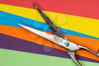 Metal scissors and multi-coloured paper sheets