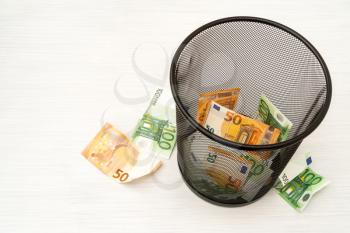 Money euro in bin. Concept of currency collapse.