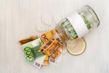 Glass jar full of money with blank label for your text