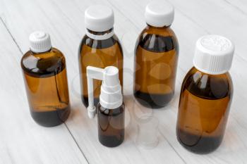 Brown glass small medical bottles on the white wooden background