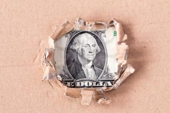 Portrait of Washington ,is depicted on the banknote of one USD, peeking through hole in paper