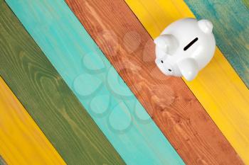  Piggy bank on color wooden background, top view