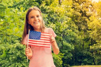 Young caucasian girl holding an American Flag