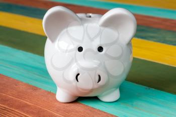 Piggy bank on color wooden background, close-up view