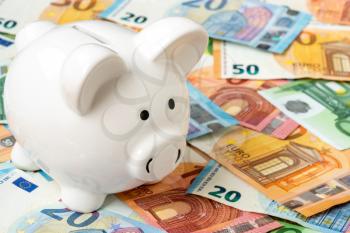 Piggy moneybox with euro cash closeup. Financial concept