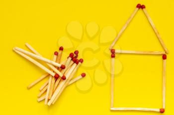 House from a matches (matches in the form of house) on a yellow background , flat lay