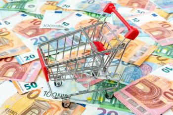 Shopping cart on euro banknotes - purchase or retail concept