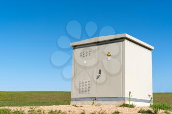  High voltage electric cabinet in park under clear blue sky