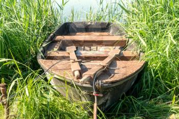 Old wooden boat on the lake bank in summer season