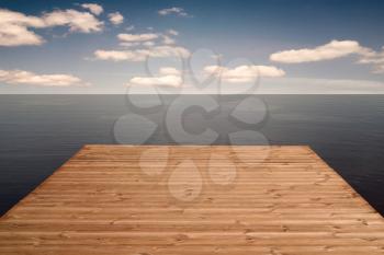     Wooden Dock or Pier in a sea under cloudy sky