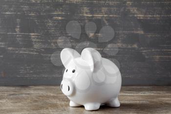 Piggy bank on wooden background. Savings concept.